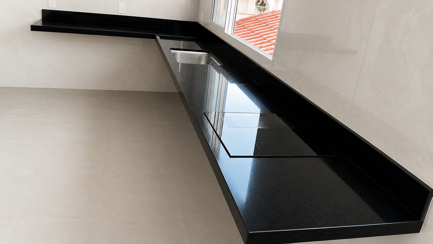 Bancada de cozinha em granito preto com cooktop e cuba